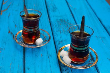 Siyah çay. Türk Ulusal içki. iyi demlenmiş çay; Tavşan kanı denir. izole mavi arka plan. yan görünümü. Metniniz için boş alan