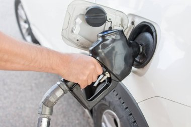 Arabanın sürücüsü dolum tabancası tanka takılı ve benzin döker