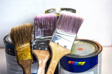 Beyaz ve sarı boya beyaz arka planı izole üç fırçalar ve kavanoz kirli