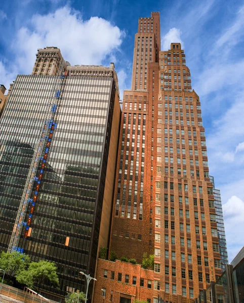 Tall buildings against a blue sky with white clouds Stock Photo