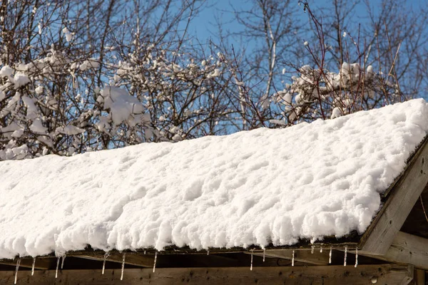 Fragmento del techo con nieve derretida y carámbanos — Foto de Stock