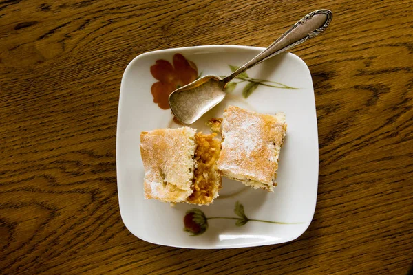 Due fette di torta di mele e un cucchiaio su un piatto — Foto Stock