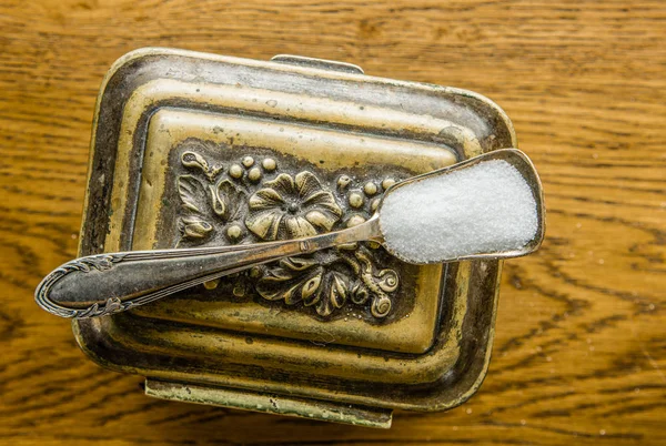 Skje med sukker på en årgangssukkerskål – stockfoto