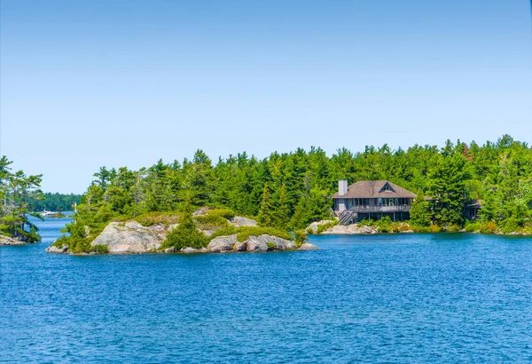 Stuga på en ö i en blå sjö — Stockfoto
