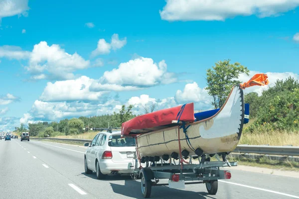 O carro puxa uma grande canoa em um trailer — Fotografia de Stock