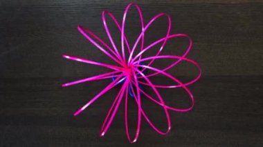 Düz telin dönen soyut modeli, kırmızıya boyanmış ve birbirine bükülmüş esnek halkalar