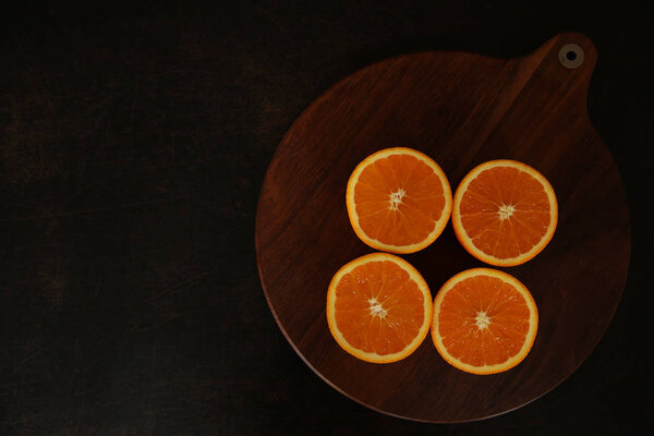 fresh juicy oranges cut in half on a brown wood background