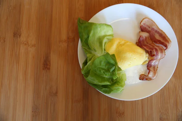 Tocino Frito Con Huevos Con Hojas Verdes Lechuga Plato Blanco — Foto de Stock