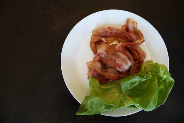 Tocino Frito Con Hojas Verdes Lechuga Plato Blanco Sobre Fondo — Foto de Stock