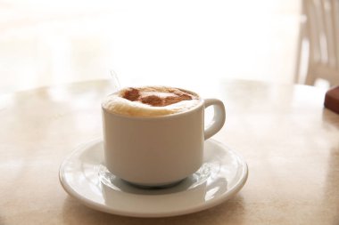 Masada bir bardak kapuçino.