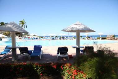 şezlonglar ve bir tropikal resort Beach Beyaz şemsiye