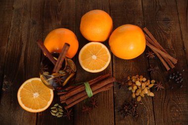 bir cam ile iki çubuk tarçın ve baharat, bunun için malzemelerle mulled şarap aromalı: tarçın, anason, kakule, biber, portakal, badem, bir ahşap zemin üzerine kuru üzüm