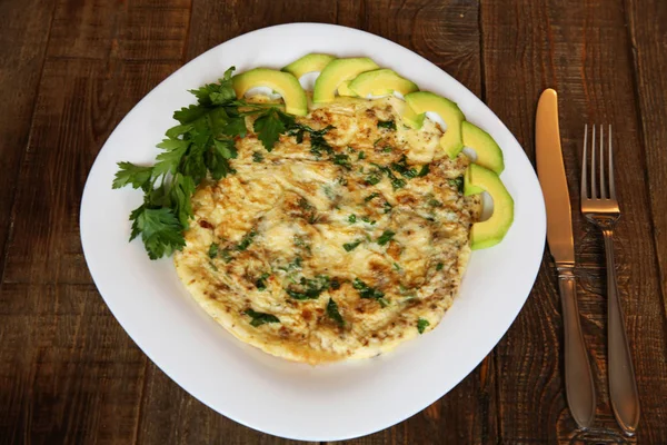 taze maydanoz ve beyaz plaka üzerinde avokado ile omlet