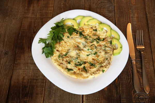 taze maydanoz ve avokado metin için yer bir ahşap meşe zemin üzerine beyaz bir plaka ile omlet