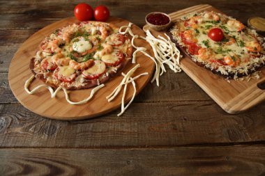 İki deniz ürünleri pizza, metin için yer bir ahşap rustik masada karides ve mozzarella peyniri