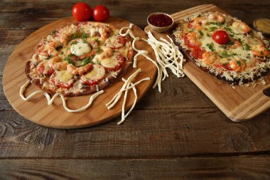 İki deniz ürünleri pizza, metin için yer bir ahşap rustik masada karides ve mozzarella peyniri