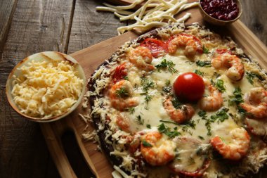 Ahşap rustik bir masada deniz ürünleri pizza, karides ve mozzarella peyniri
