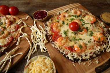 Ahşap rustik bir masada deniz ürünleri pizza, karides ve mozzarella peyniri