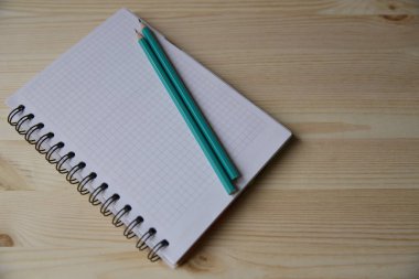 Boş defter ve ahşap masa lambası üzerinde iki kalem