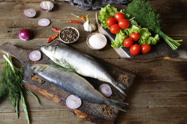 domates ve baharat bir kesme tahtası üzerinde taze ringa balığı