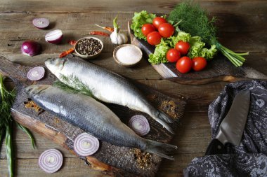 domates ve baharat bir kesme tahtası üzerinde taze ringa balığı