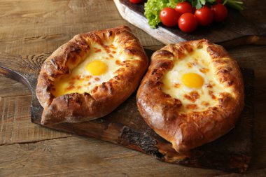 Akın kılınç ahşap tahtaları üzerinde peynir ve yumurta ile bir tekne şeklinde pişmiş ekmek olduğunu. Geleneksel Gürcü yemekleri.