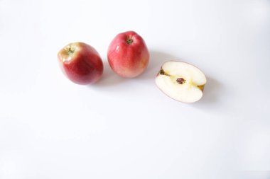  iki kırmızı elma ve beyaz arka planda izole yarım elma