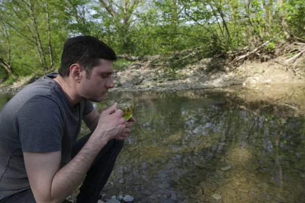 Ormanda Nehrin Kıyısında Oturan Bitkisel Çay Içme Aktif Adam — Stok fotoğraf