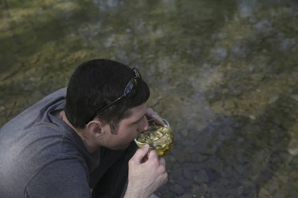 Ormanda Nehrin Kıyısında Oturan Bitkisel Çay Içme Aktif Adam — Stok fotoğraf