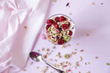  Açık pembe arka plan üzerinde taze ahududu çilek ile Granola yoğurt parfait. Sağlıklı yiyecekler. Metin için kopyalama alanı ile. Düz yatıyordu