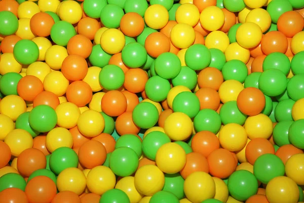 Bakgrund Färgade Plastbollar Grön Gul Orange För Ett Barns Spel — Stockfoto