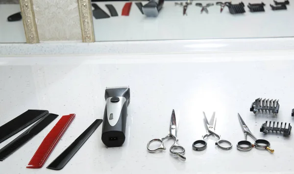 Set of professional hairdressing tools with reflection of tools in a mirror on a white background. Concept for hairdressers and barbershop.