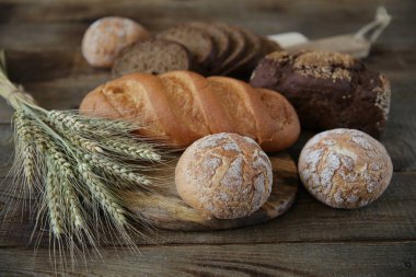 çavdar ve kulakları ile buğday taze sıcak ekmek, ahşap rustik arka plan üzerinde yakın çekim