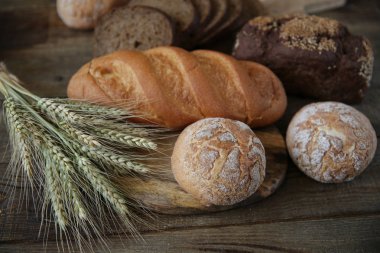 çavdar ve kulakları ile buğday taze sıcak ekmek, ahşap rustik arka plan üzerinde yakın çekim