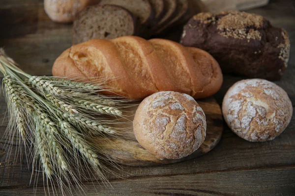 çavdar ve kulakları ile buğday taze sıcak ekmek, ahşap rustik arka plan üzerinde yakın çekim