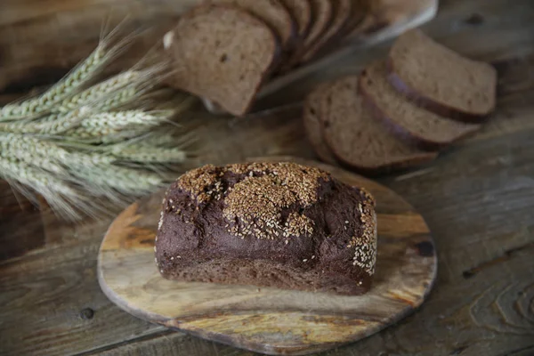 çavdar ekmeği ve ahşap rustik arka plan üzerinde çavdar kulakları. Düz Lay.