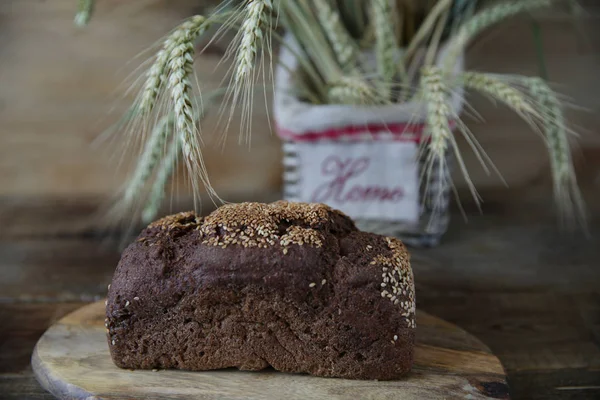 Close. Ahşap rustik arka plan üzerinde yazıt Ev ile bir sepet içinde susam ve çavdar kulakları ile Çavdar ekmeği