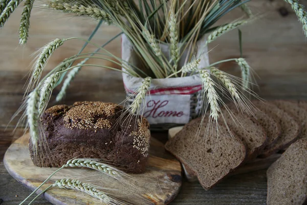 Close. Ahşap rustik arka plan üzerinde yazıt Ev ile bir sepet içinde susam ve çavdar kulakları ile Çavdar ekmeği
