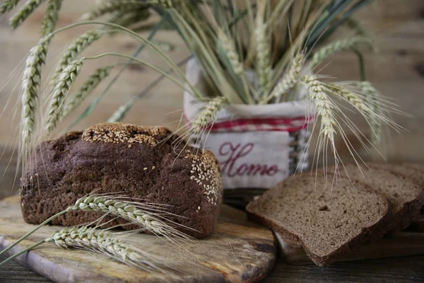 Close. Ahşap rustik arka plan üzerinde yazıt Ev ile bir sepet içinde susam ve çavdar kulakları ile Çavdar ekmeği