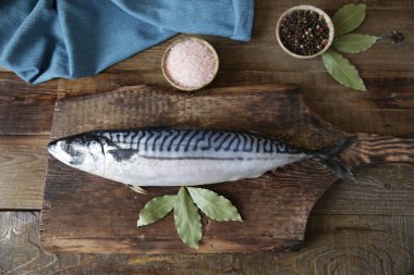 Ahşap kesme tahtası ve metin için kopya alanı ile ahşap rustik arka plan üzerinde baharat ile taze uskumru, düz yatıyordu. Üstte görüntü.