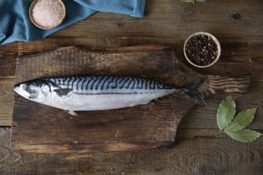 Ahşap kesme tahtası ve metin için kopya alanı ile ahşap rustik arka plan üzerinde baharat ile taze uskumru, düz yatıyordu. Üstte görüntü.