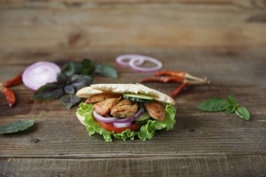 Closeup. Pide - sandviç, tavuk, domates, salatalık, sebze ve biber ile dekore ahşap bir rustik arka plan üzerinde salata ile doldurulmuş sabiche. Orta Doğu mutfağı. Metin için kopyalama alanı ile.