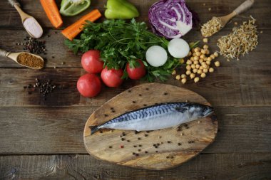 Taze uskumru sebze, filizlenmiş fasulye ve otlar ve baharatlar ahşap bir masa üzerinde ahşap bir kesme tahtası üzerinde izole. Sağlıklı yiyecekler. Akdeniz diyeti.