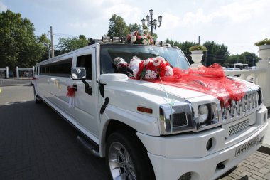 Krasnodar/Rusya-07.20.2019: beyaz Hummer düğün limuzin kırmızı şeritler, Alyans ve çiçekler ile dekore edilmiştir. Düğün konsepti.