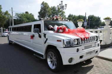 Krasnodar/Rusya-07.20.2019: beyaz Hummer düğün limuzin kırmızı şeritler, Alyans ve çiçekler ile dekore edilmiştir. Düğün konsepti.