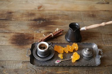 metin ve görüntü için kopya alanı ile ahşap bir rustik masa üzerinde cezve ve tatlılar ile vintage desenli fincanlarda türk kahvesi. Natürmort. Gastronomik seyahat.