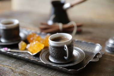 Yakın çekim Ahşap rustik bir masada Türk ve tatlı karamel şeker ile ulusal Türk tarzında oryantal kahve bir fincan. Gastronomik Seyahat.
