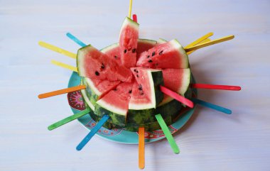 metin için kopya alanı ile ahşap açık mavi arka plan üzerinde renkli çubukları ile taze kırmızı dilimlenmiş karpuz. Organik sağlıklı yiyecekler. Detoks, diyet.