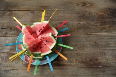 metin için kopya alanı ile ahşap bir rustik arka plan üzerinde renkli çubukları ile taze dilimlenmiş karpuz. Sağlıklı gıda, diyet detoks.