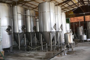 birbira ve şarap fabrikasında parlak tanklar veya variller. Sanayi Bira ve şarap yapımı. Bir fabrikanın şaraphane ve bira endüstriyel iç için ekipman